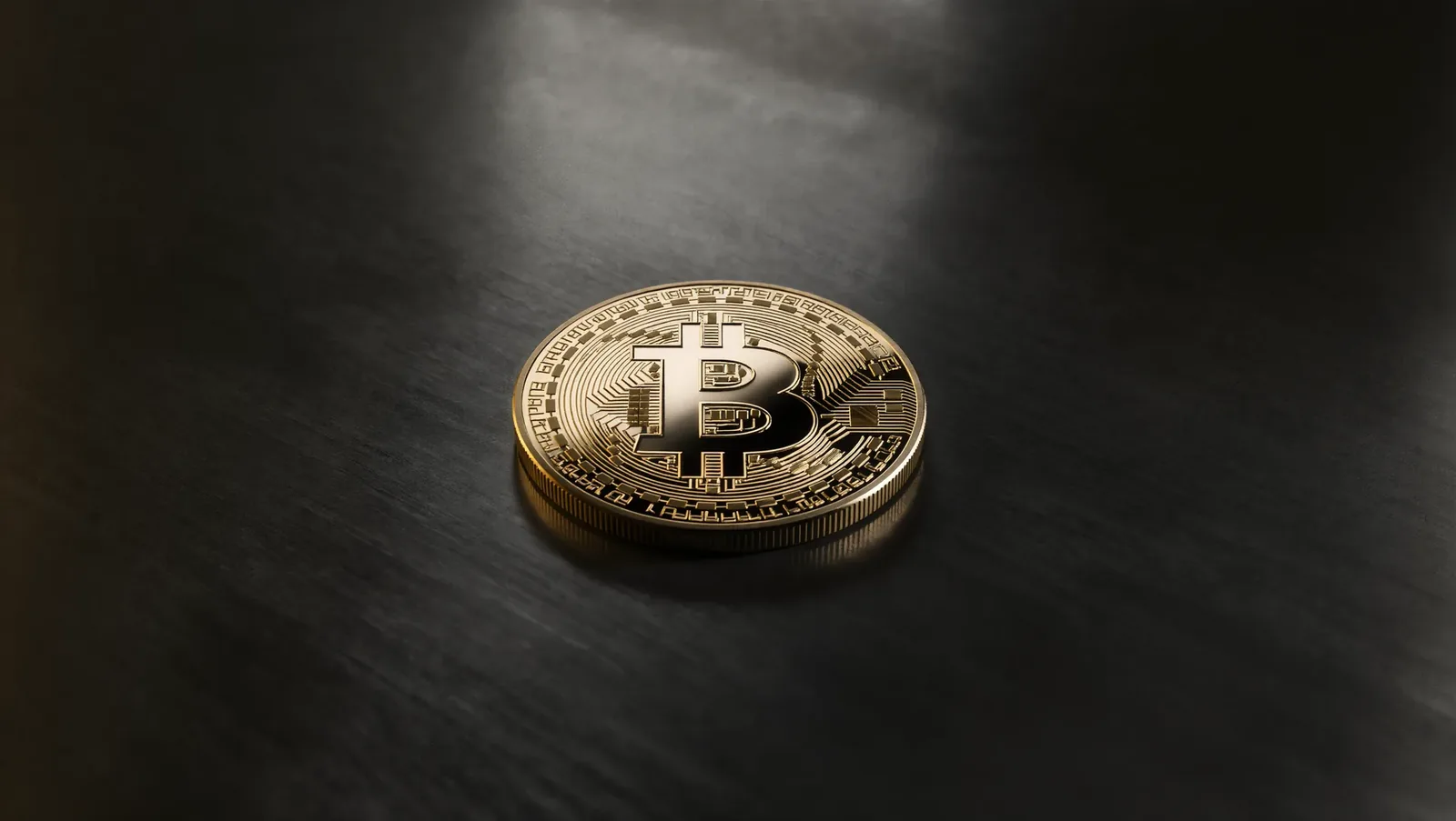 Symbolbild einer halbierten goldenen Bitcoin-Münze über einem Raster aus Blöcken und Zahlen